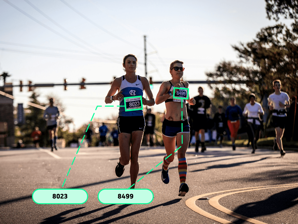 Race finish line - runners crossing with bib numbers